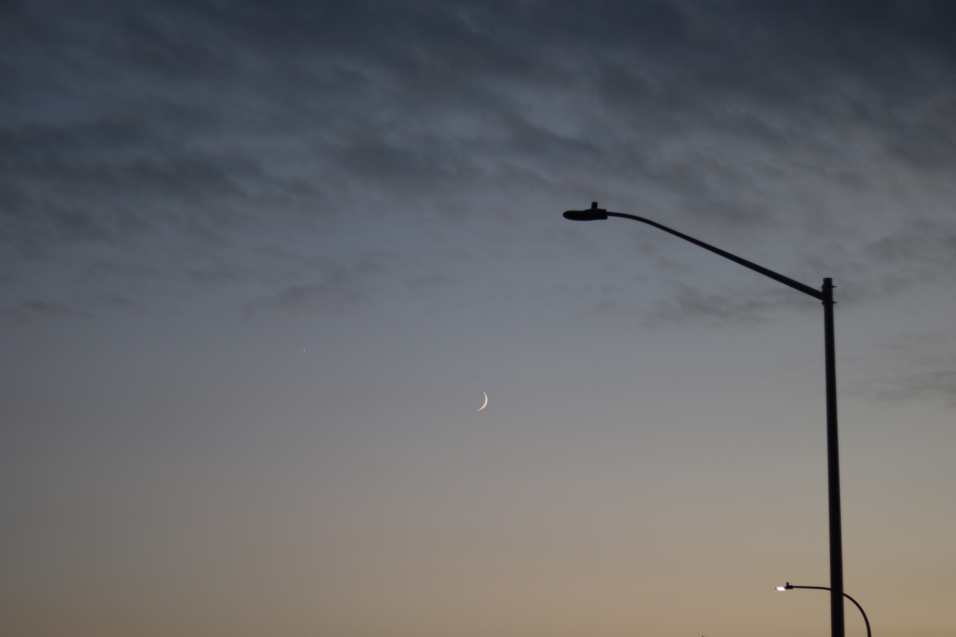 A cloudy sky, with a single lamp post on the right