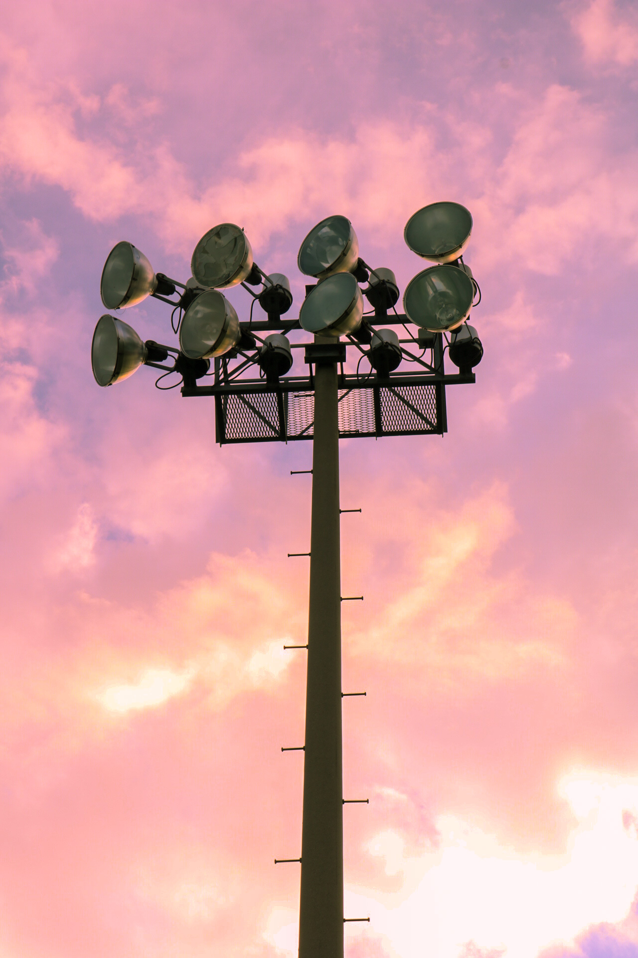 A stadium light depicted with a cotton-candy-like sky in the background