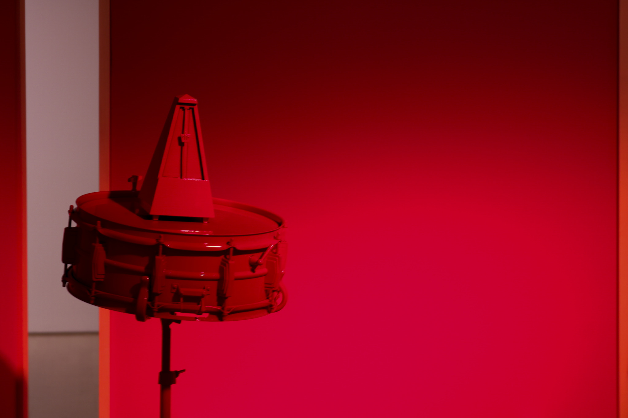 A red snare drum set in front of a red backdrop