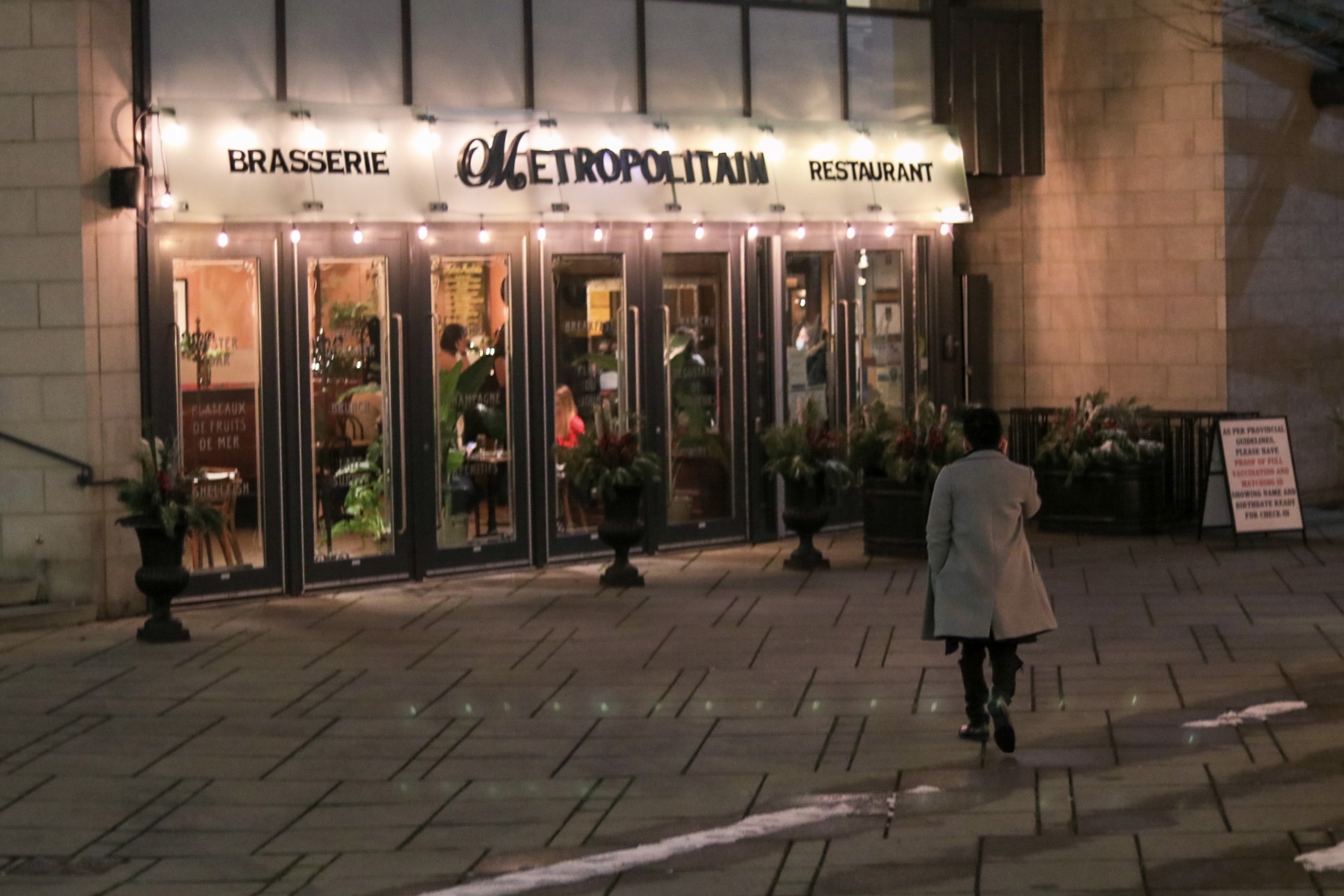 A man walking into 'La Brasserie, Metropolitain'