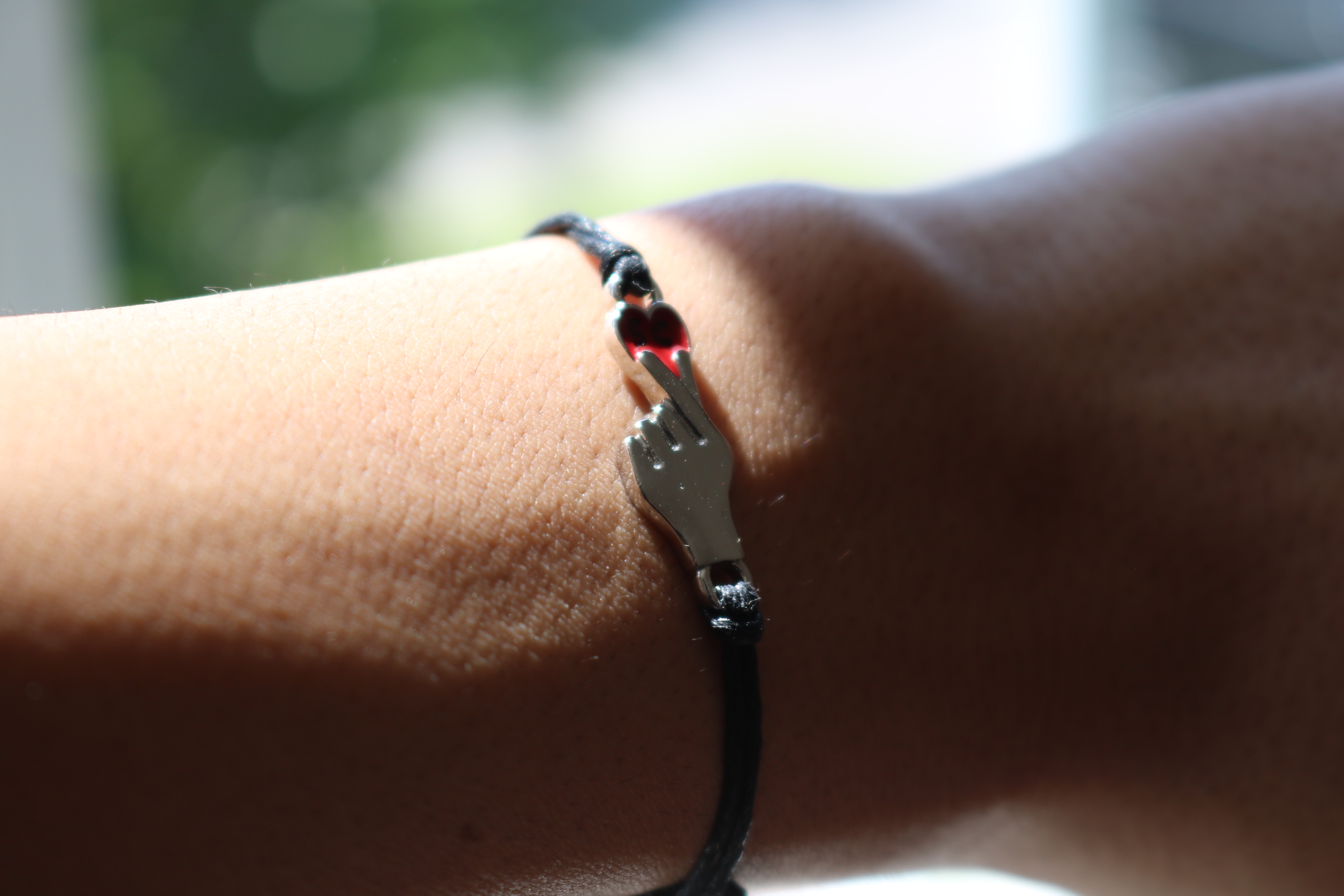 A bracelet with a finger heart charm